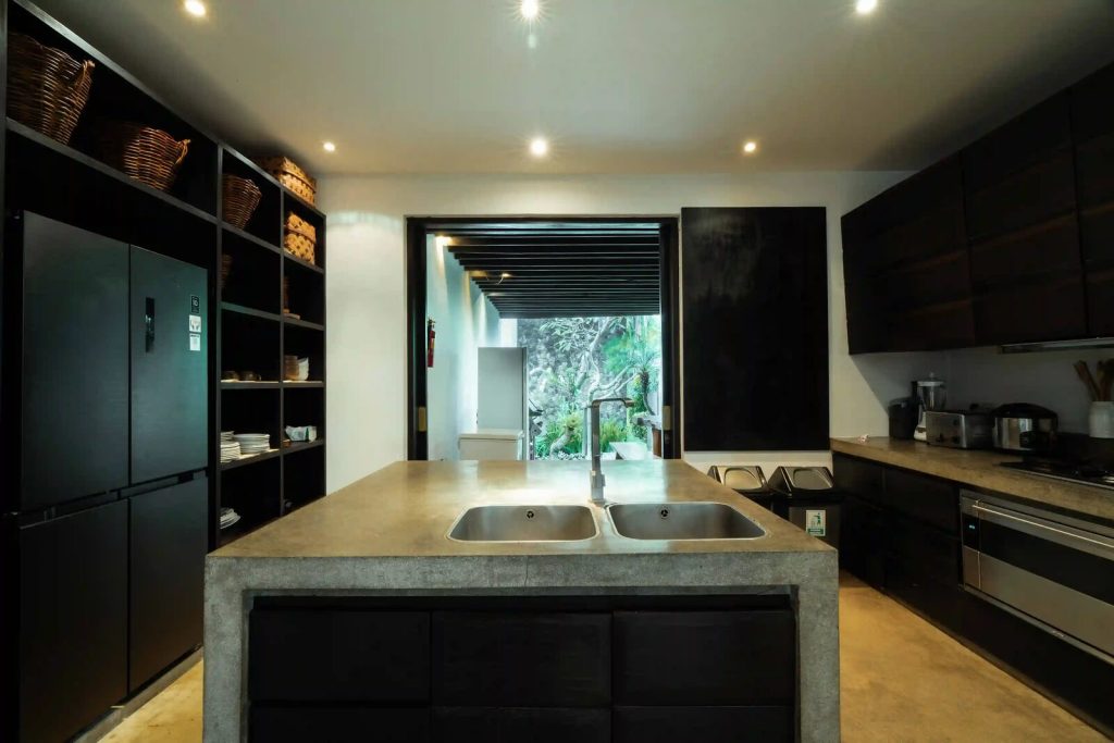 Villa kitchen with a concrete island and double sink in Bali