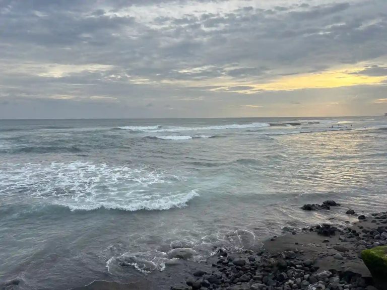 Waves rolling onto the black-sand shore of Echo Beach, Canggu