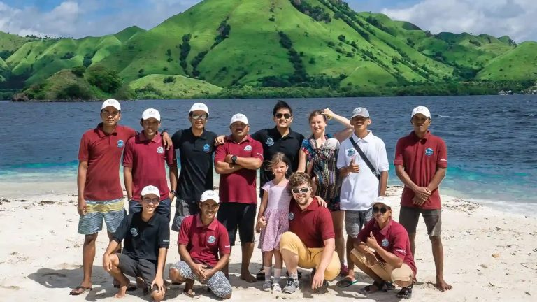 Uniformed hospitality team with guests on the beach